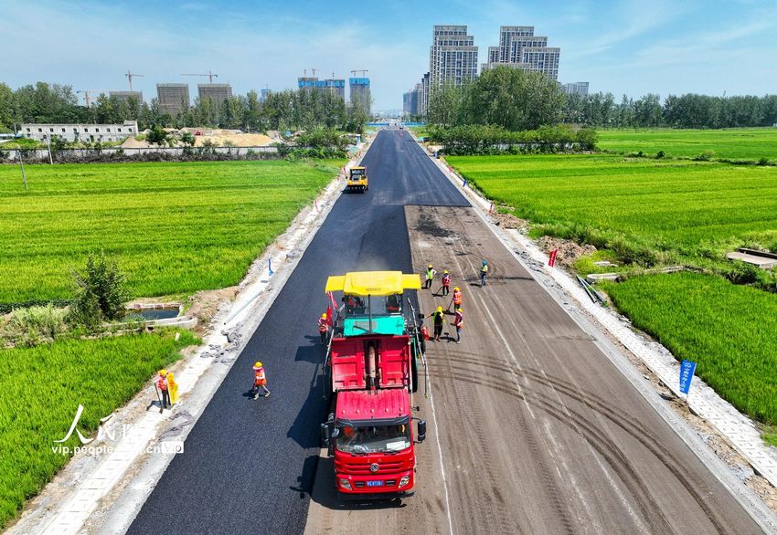 施工人員正在為鹿門山旅游道路攤鋪瀝青。