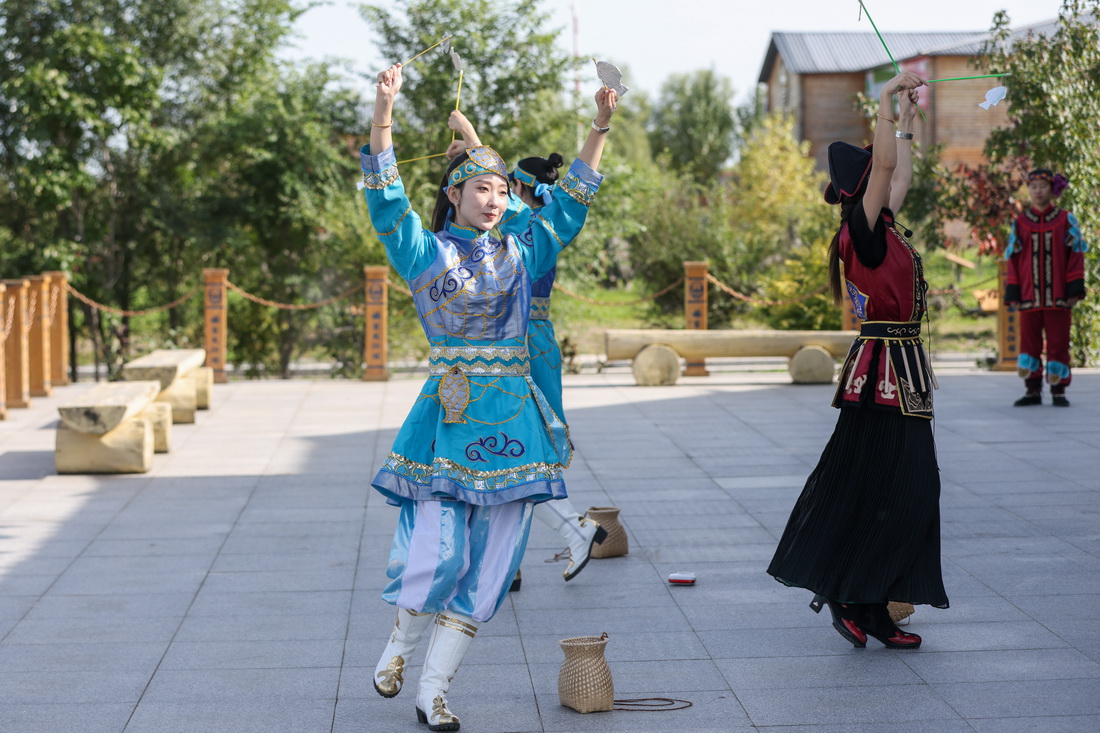 9月4日，在黑龍江撫遠市烏蘇鎮抓吉赫哲族村赫哲民俗展示館前，尚美含（左一）和赫哲族青年一起表演民族舞蹈。新華社記者 張濤 攝