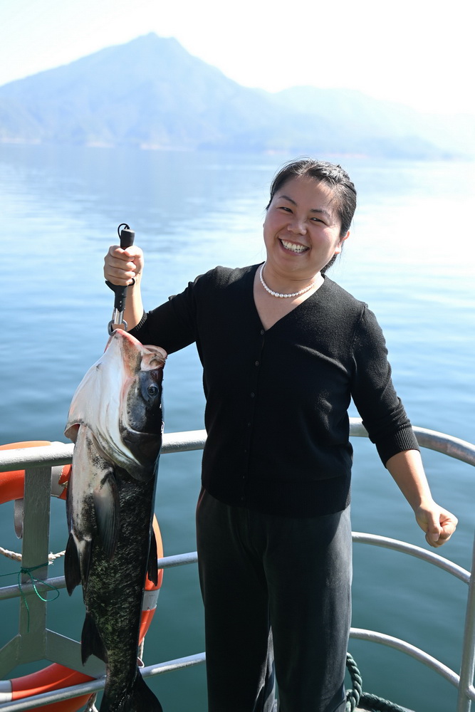 10月22日，在浙江省淳安縣千島湖黃山尖水域，游客用力提起剛捕獲的“魚王”。