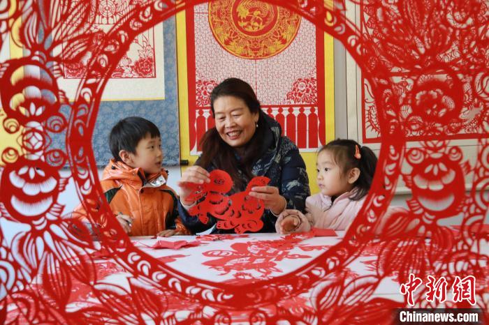 非遺傳承人田桂芹在帶領孩子們進行迎新年剪紙創(chuàng)作?！±詈?攝