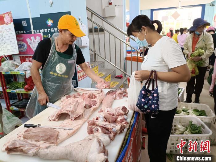 资料图：海口市民在农贸市场购买肉类。　张月和 摄
