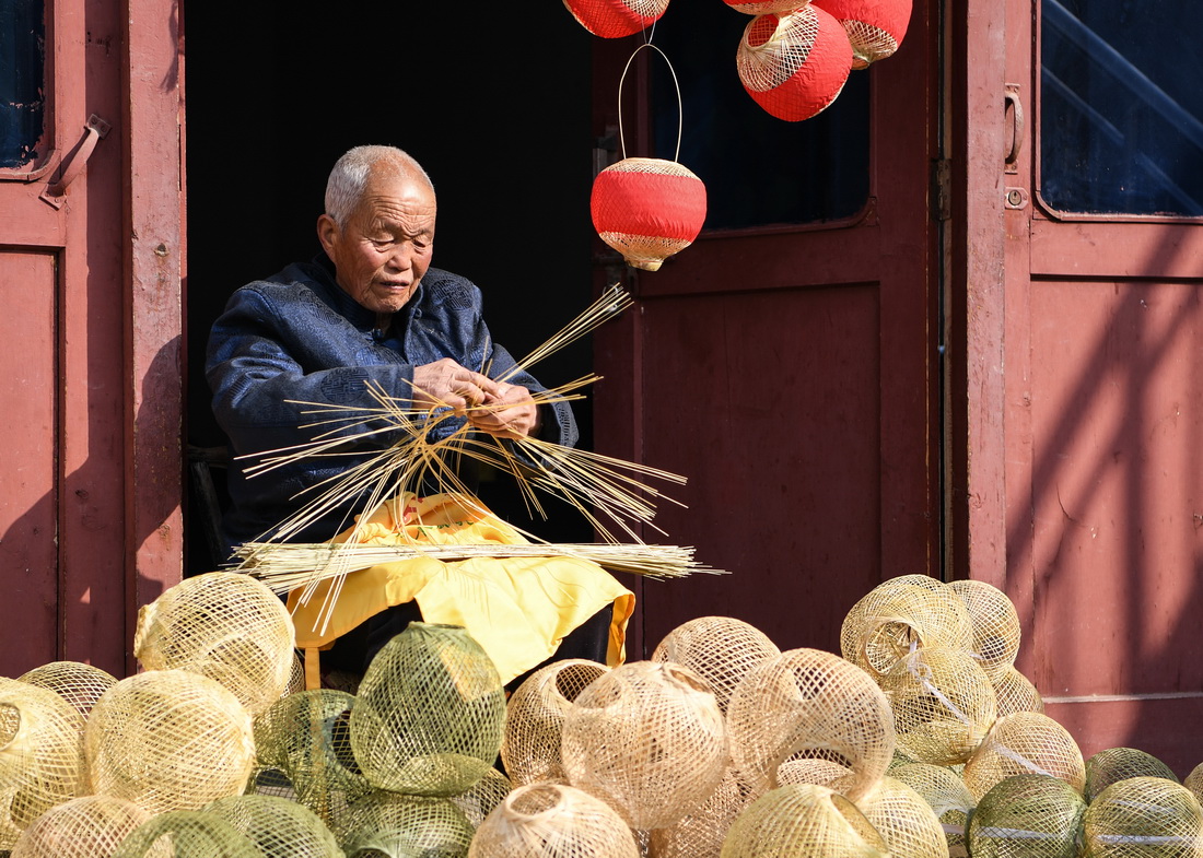 王学坤在编织竹篾灯笼（2月4日摄）。