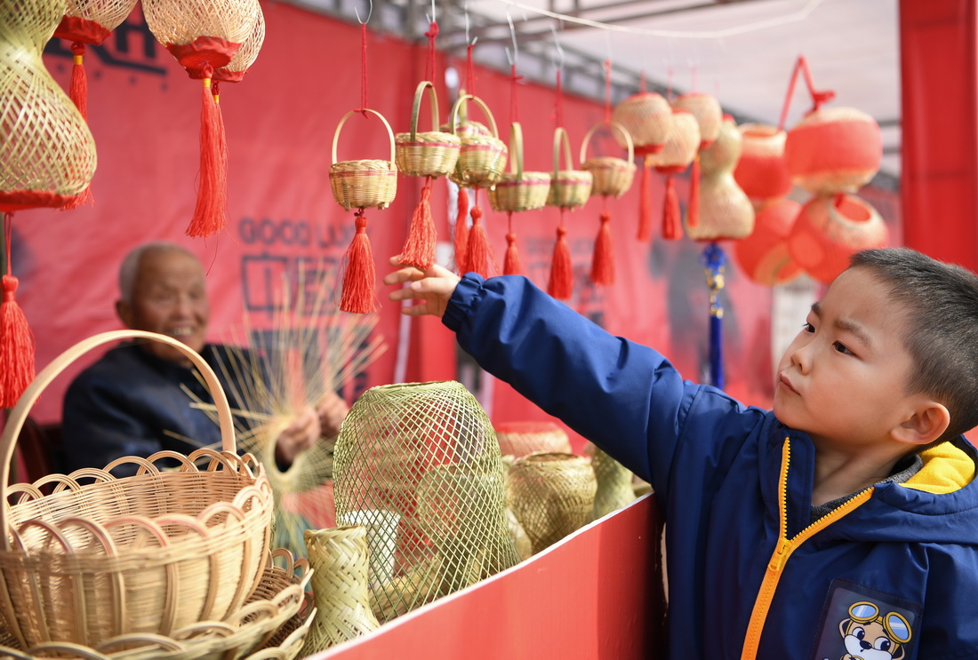王学坤在西安市灞桥区白鹿原上的非遗基地展位销售竹篾灯笼（2月4日摄）。