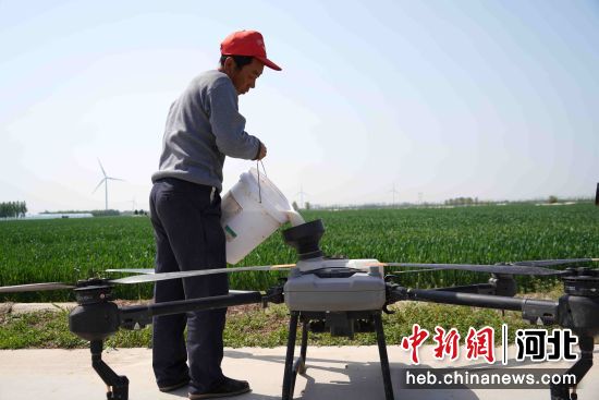 在河北省邢台市巨鹿县周于庄村的麦田边，工人正在装药。 甄燕