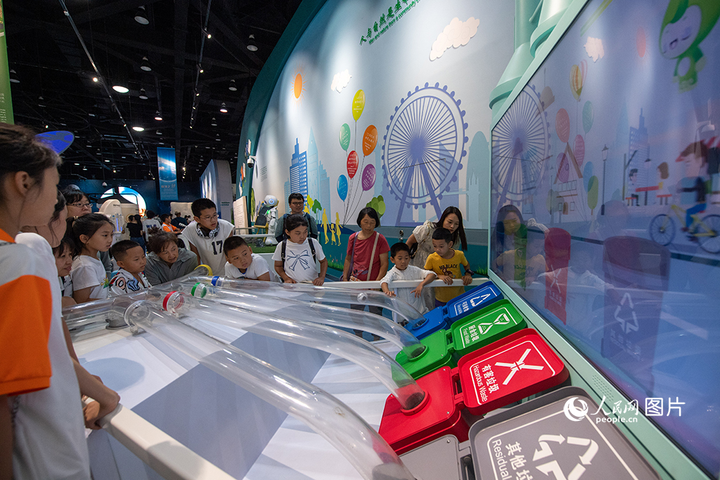 7月19日，在中国科学技术馆，孩子们参与趣味问答，学习垃圾分类的相关知识。通过寓教于乐的方式提升孩子环保理念，从小培养爱护环境、保护生态的意识。人民网记者 翁奇羽摄