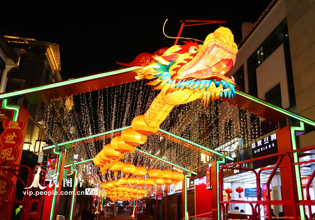 2024年2月7日晚，由苏州传统彩灯艺人设计赶制的一条巨型“金龙”在观前旅游商业街心吊装完毕，调试亮灯，吸引市民游客驻足。王建中摄（人民图片网）