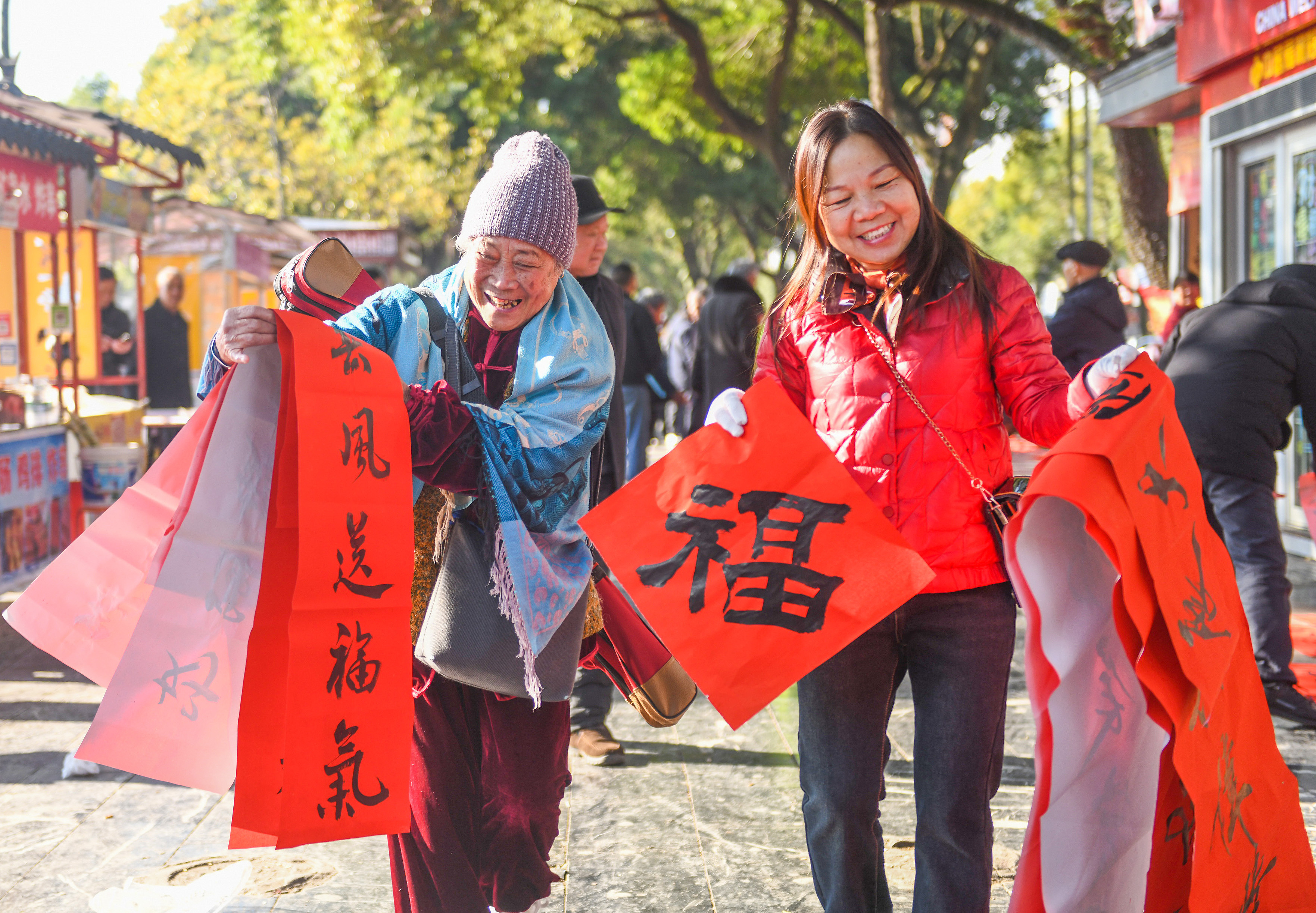 2025年1月13日，在湖南省永州市道縣西洲公園義工崗亭，市民們領到了書法志愿者為大家書寫的春聯(lián)。