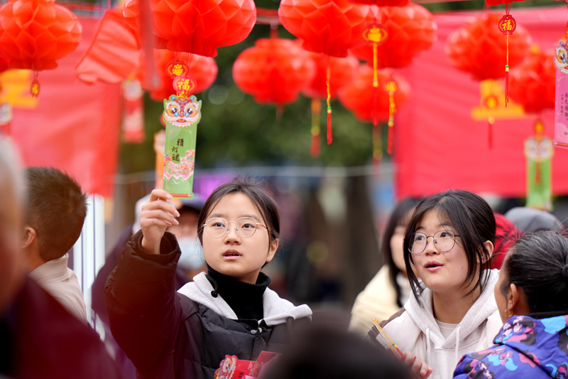 2月10日，江西省宜春市上高县敖阳街道和平居委会的居民正在猜灯谜。陈旗海摄