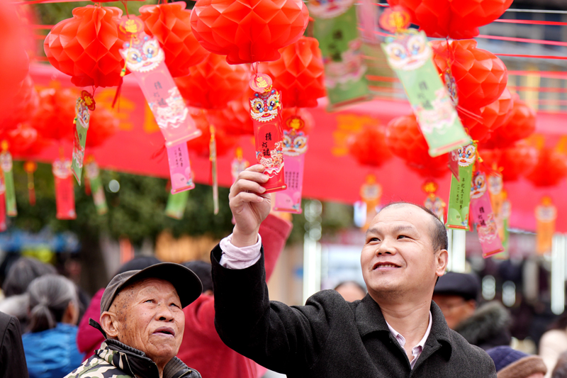 2月10日，江西省宜春市上高县敖阳街道和平居委会的居民正在猜灯谜。陈旗海摄