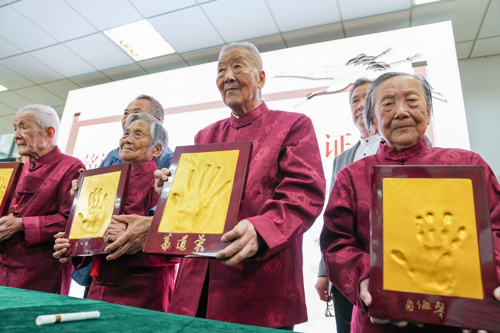 2022年10月4日，南京大屠殺幸存者夏淑琴、葛道榮、薛玉娟和王義隆（前排，從右到左）在侵華日軍南京大屠殺遇難同胞紀(jì)念館舉辦的重陽節(jié)活動上展示手印。新華社記者 李博 攝