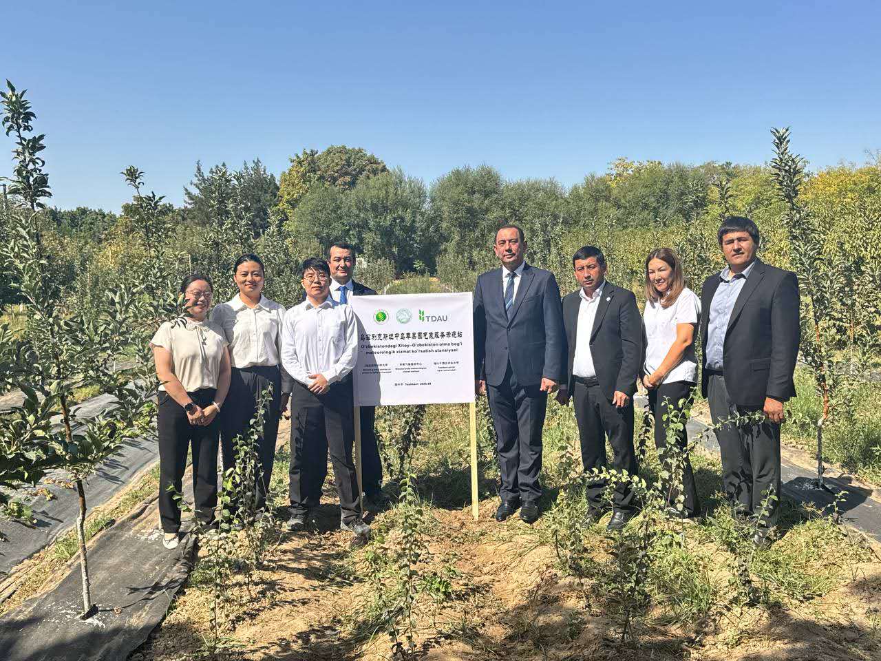 西北農(nóng)林科技大學(xué)教師代表和塔什干國立農(nóng)業(yè)大學(xué)副校長阿布杜阿齊茲·阿布杜瓦西科夫（右四）等在中烏果木良種繁育技術(shù)示范園共同祝賀氣象服務(wù)示范站揭牌