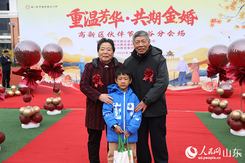 一对老人携孙子在现场打卡合影。他们历经岁月沉淀的灿烂笑容，生动诠释了“执子之手，与子偕老”的动人画面。人民网记者 刘祺摄