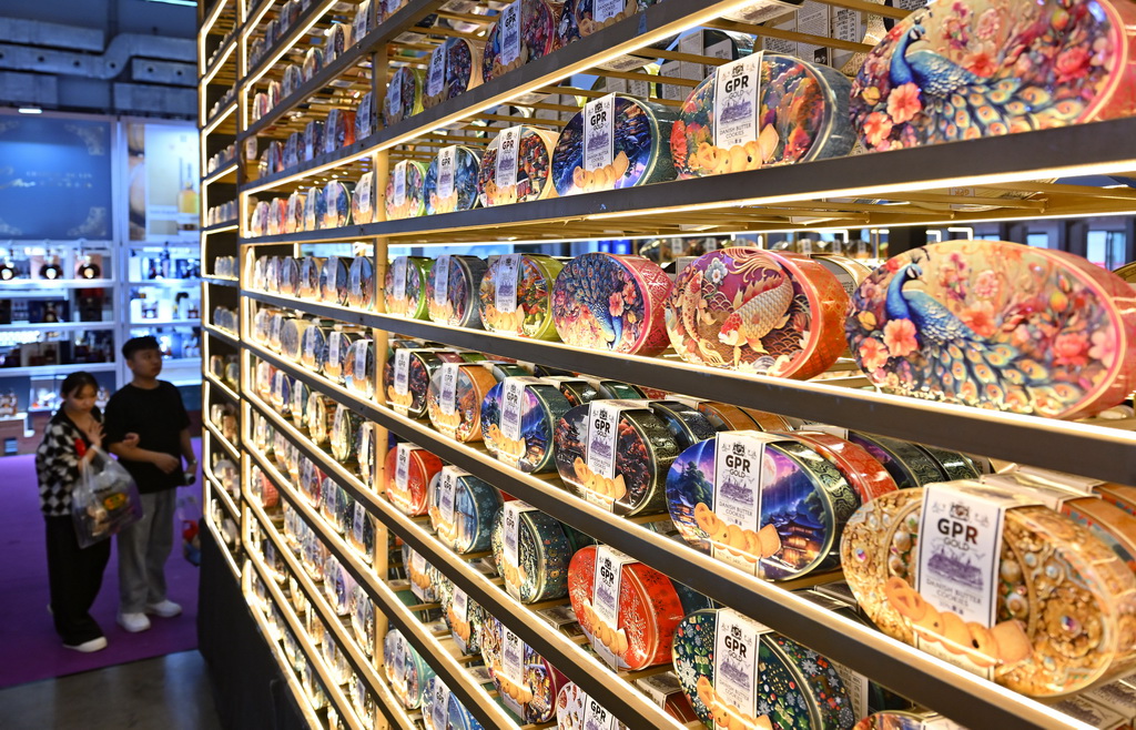 12月4日，观众在海南冬交会现场选购马来西亚饼干。