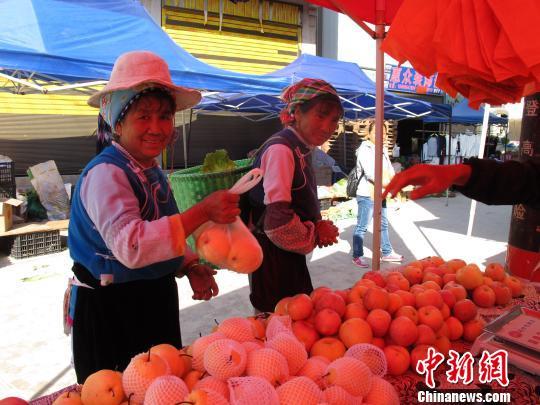 資料圖：村民在鄉(xiāng)街購(gòu)買水果?！埖?攝